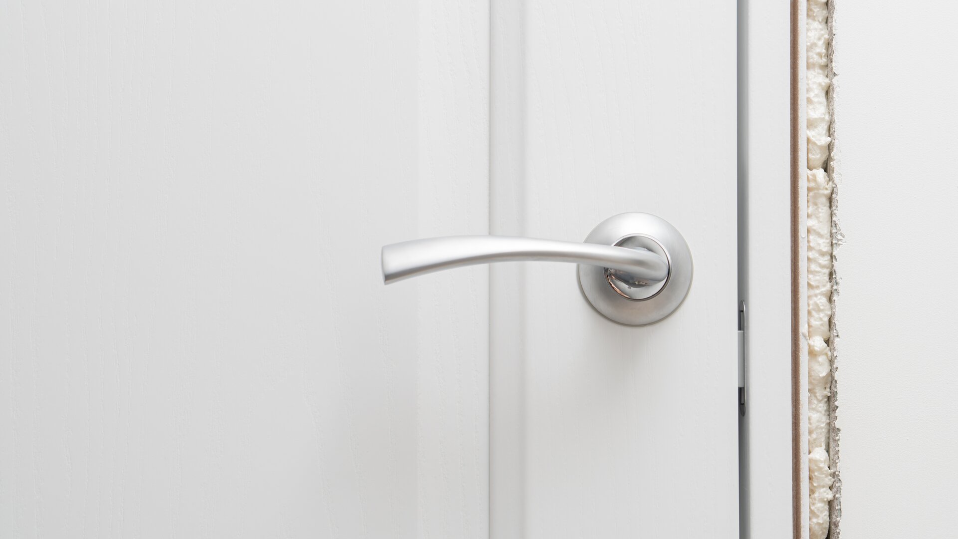 Close-up of a door fixed and insulated with the help of foam.