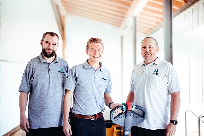 Three Ramsauer employees in grey Ramsauer shirts. 