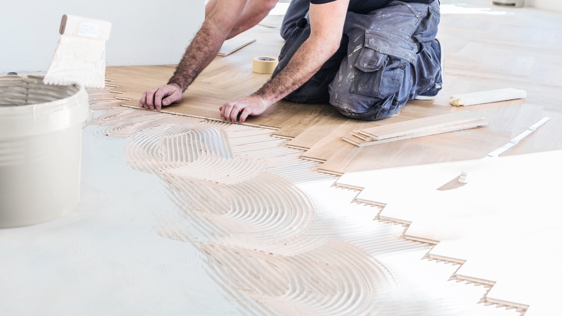 Ramsauer employee bonding the wooden floor board by board.