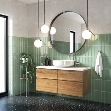 Modern bathroom with green tiles, large round mirror and bathroom cabinet with wooden front.