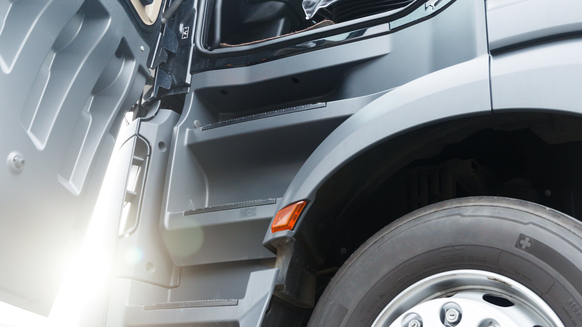 Close-up of the body of a truck with the driver's door open.